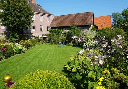 Rückseite des mit Sandsteinschindeln verkleideten Herrenhaus Lütmarsen mit Garten