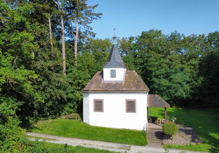 Kleine weiße Kapelle auf einer geschützten Waldlichtung