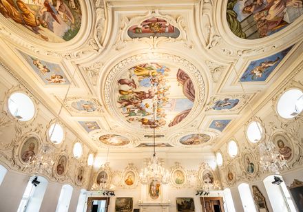 Blick unter die Stuck verzierte Decke mit Kaiserbildern