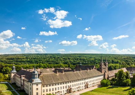 Luftbilaufnahme von Corvey mit blauem Himmel und weißen Wolken