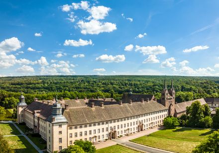 Luftbildaufnahme von Corvey mit blauem Himmel und weißen Wolken