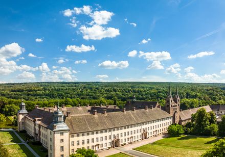 Luftbilaufnahme von Corvey mit blauem Himmel und weißen Wolken