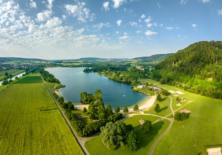Luftaufnahme des Badesees der Freizeitanlage Höxter-Godelheim mit Badestrand im Vordergrund