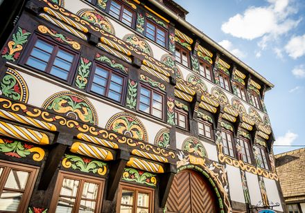 Aufwendig gestaltete Fachwerkfassade, reich verziert mit Schnitzereien und buntem Anstrich